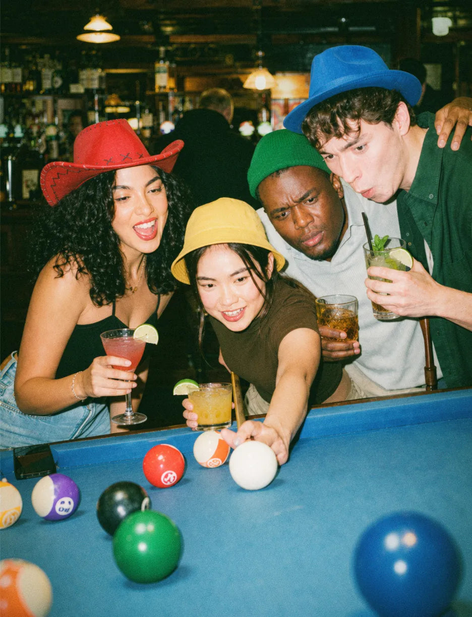 Friends playing pool in a pub during a pub golf night