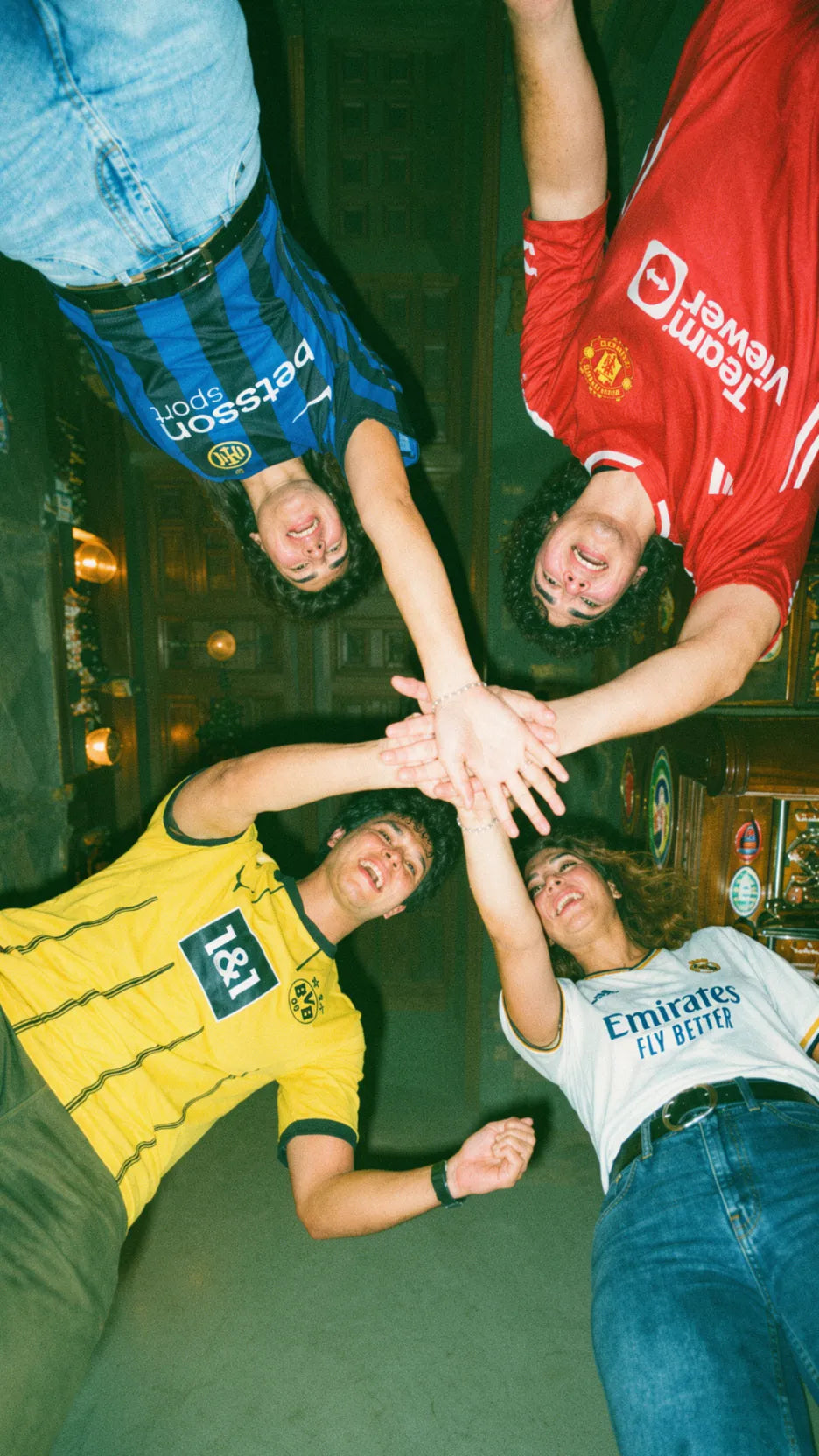 Group of friends in football jerseys forming a team huddle during a pub golf night